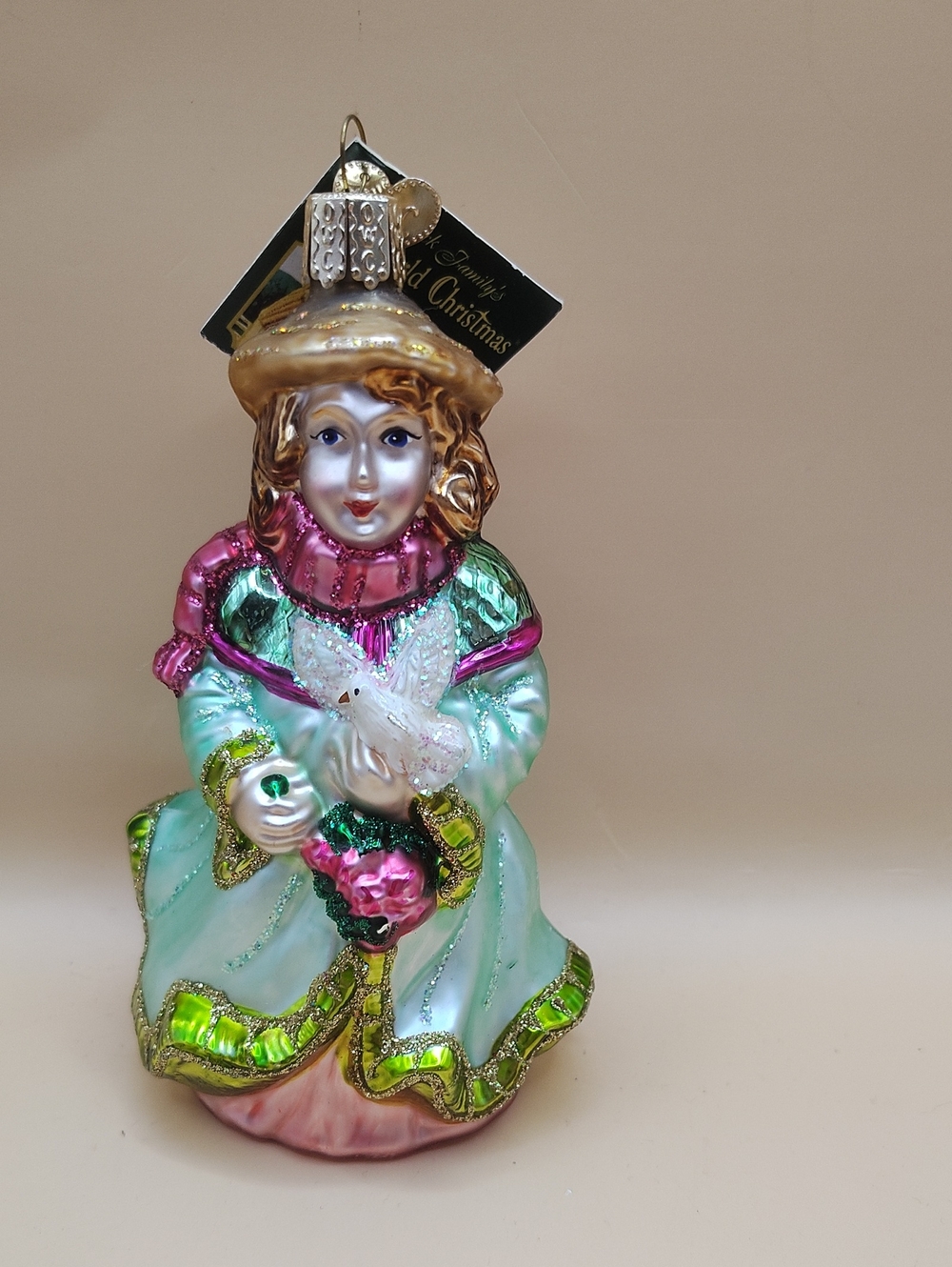 Old World Christmas glass ornament featuring a girl or angel holding white dove